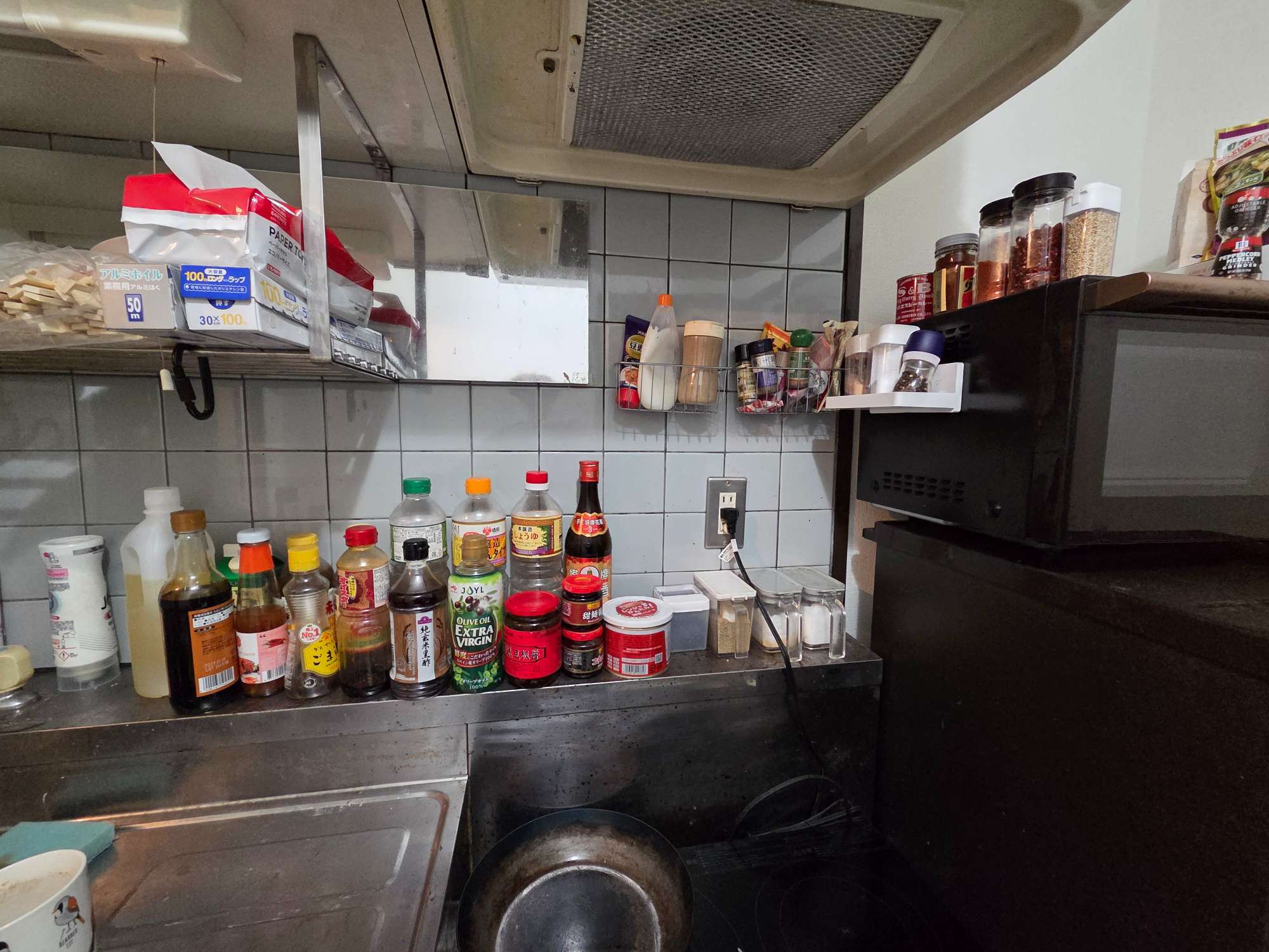 DIY前のキッチン。調味料がカウンターに散乱している。