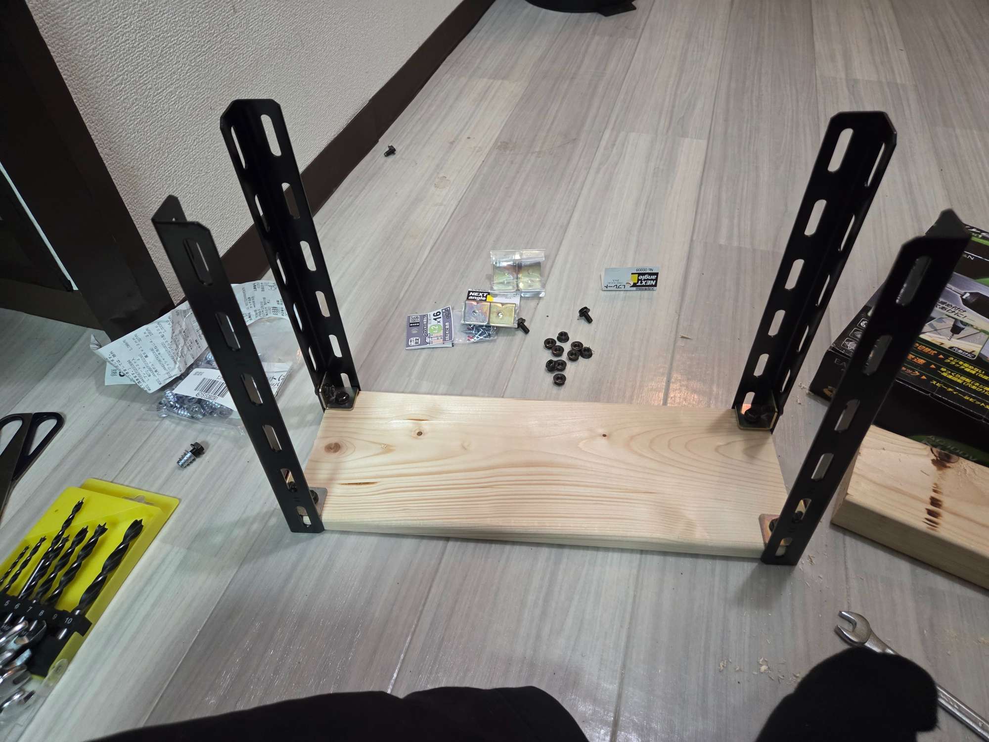 黒いカラーアングル2本と底板が組み合わさった棚の骨格。